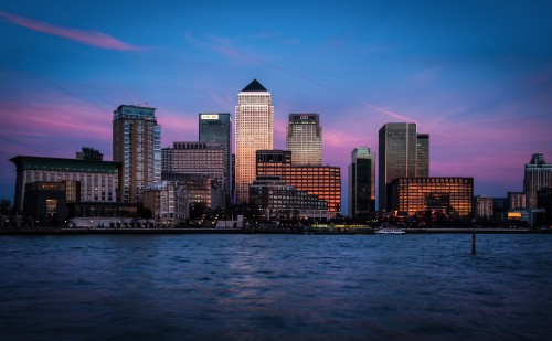 Image city skyline across body of water during night time