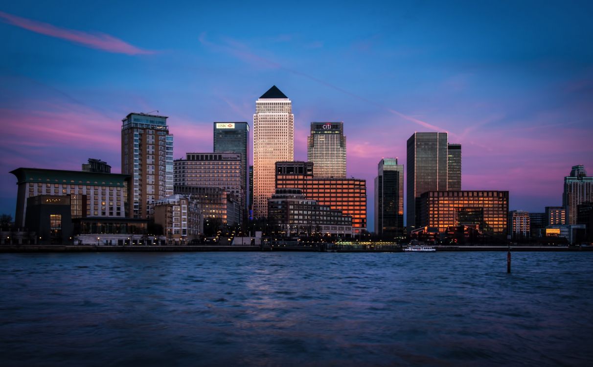 city skyline across body of water during night time