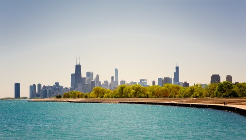 Image city skyline across body of water during daytime