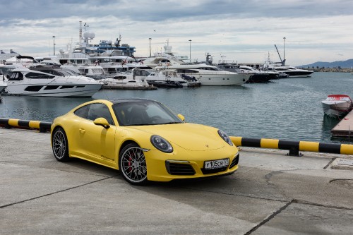 Image yellow ferrari 458 italia parked on gray concrete pavement near body of water during daytime