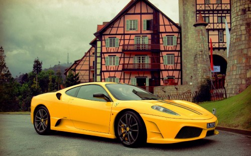 Image yellow ferrari 458 italia parked beside brown brick building