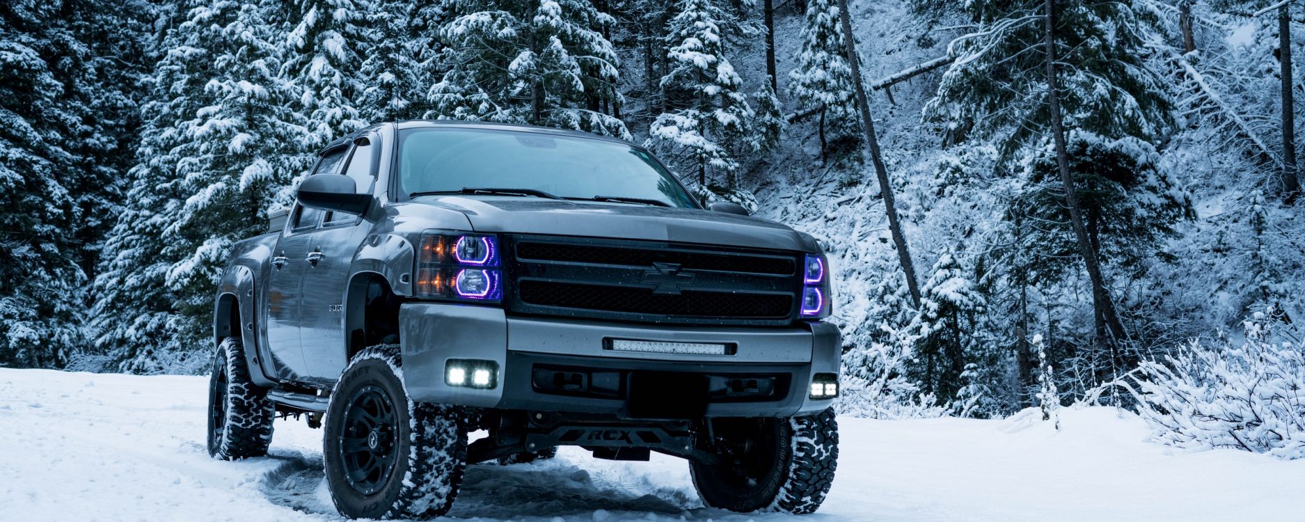 Grauer Ford SUV Auf Schneebedecktem Boden. Wallpaper in 2560x1024 Resolution