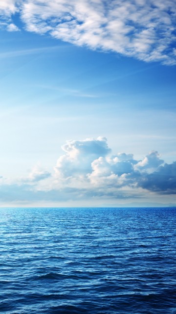 Image blue sea under blue sky and white clouds during daytime