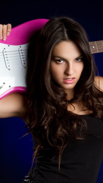 Image woman in black tank top holding white and pink electric guitar