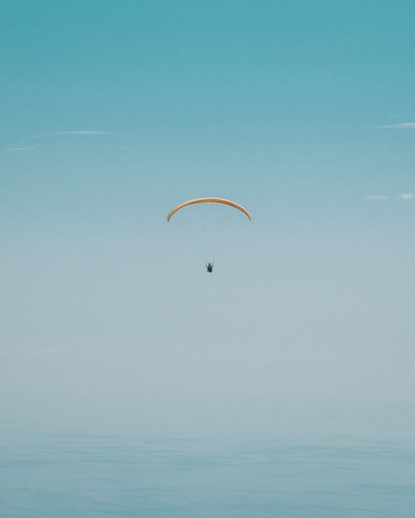 Persona en Paracaídas Bajo un Cielo Azul Durante el Día.. Wallpaper in 2964x3705 Resolution