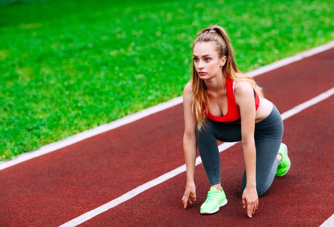 Frau in Schwarzem Tanktop Und Grünen Shorts, Die Tagsüber Auf Dem Track Field Läuft Running. Wallpaper in 4868x3308 Resolution