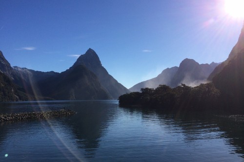 Image body of water near mountain under blue sky during daytime