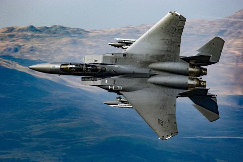 Image gray fighter jet flying over blue sky during daytime