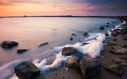 Image rocky shore with sea waves crashing on rocks during daytime