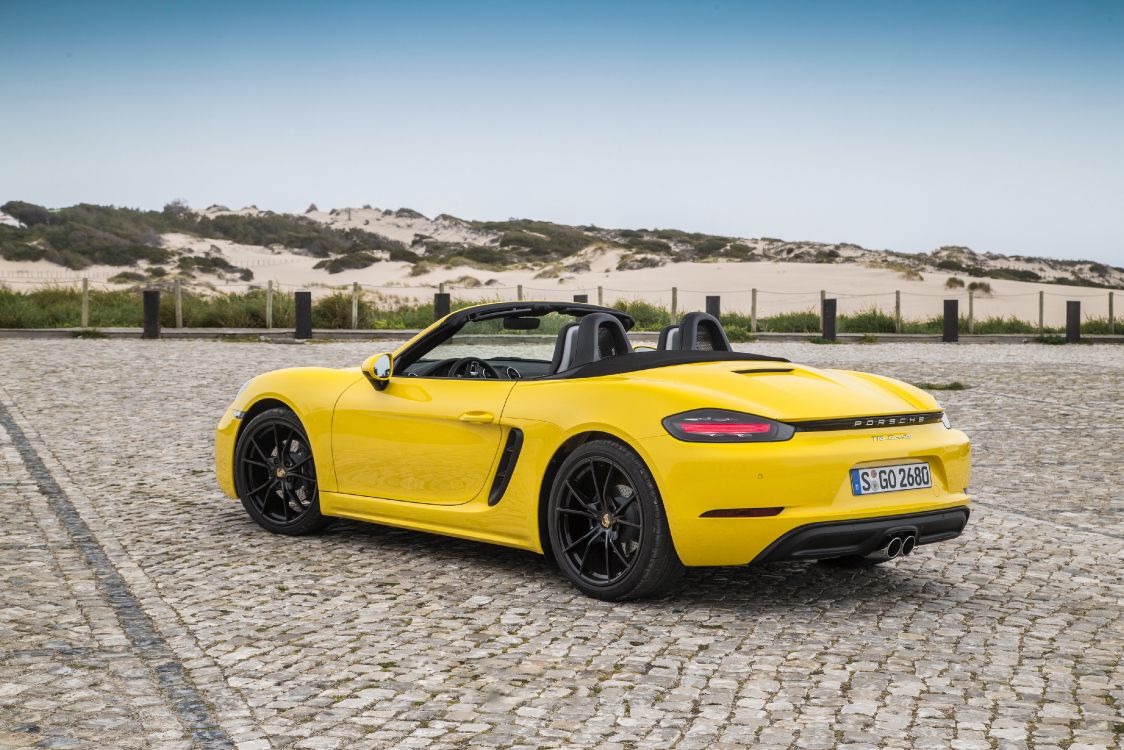 yellow porsche 911 on gray sand during daytime