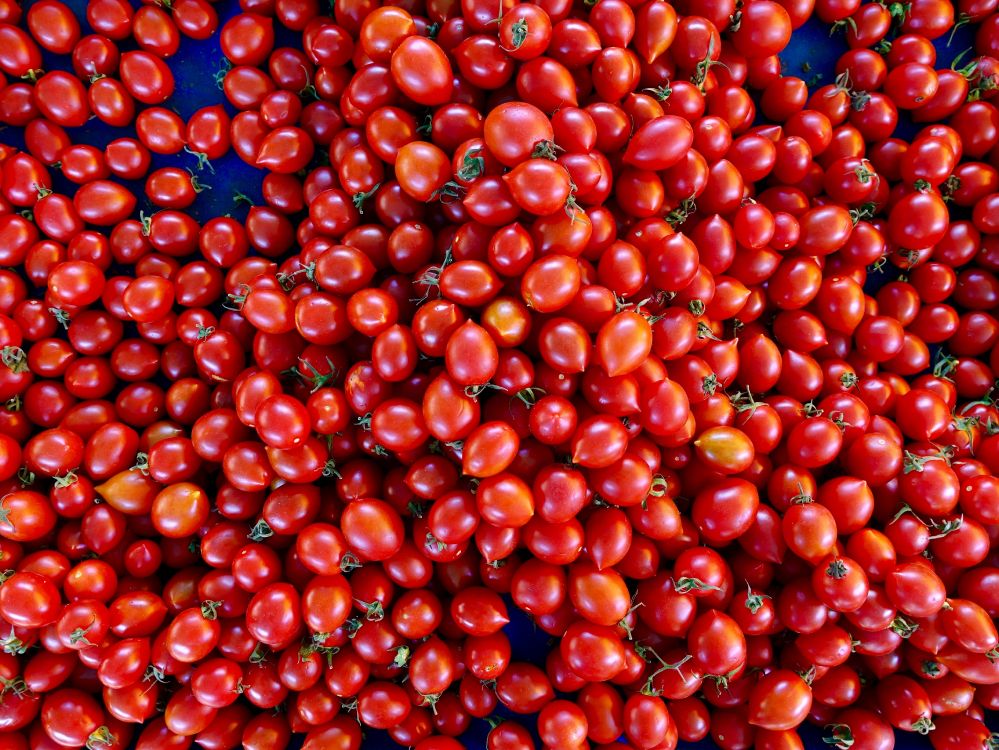 Red Round Fruits on Blue Plastic Container. Wallpaper in 4864x3648 Resolution