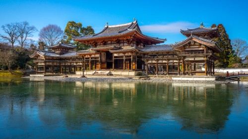 Image brown and white temple near body of water during daytime