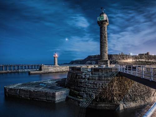 Image white and black lighthouse near body of water during daytime