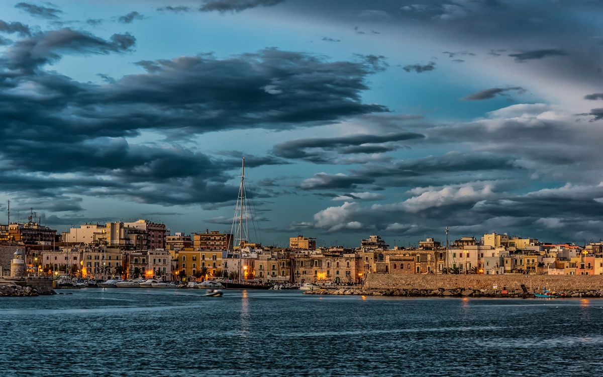 Bâtiments de la Ville Près D'un Plan D'eau Sous un Ciel Nuageux Pendant la Journée. Wallpaper in 2880x1800 Resolution