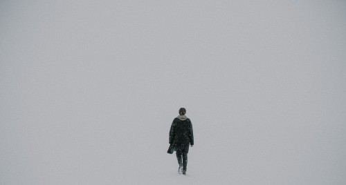 Image man in black jacket standing on snow covered ground