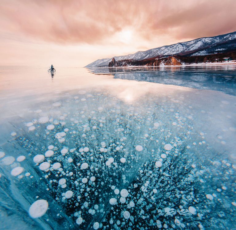 person standing on snow covered ground near mountain during daytime