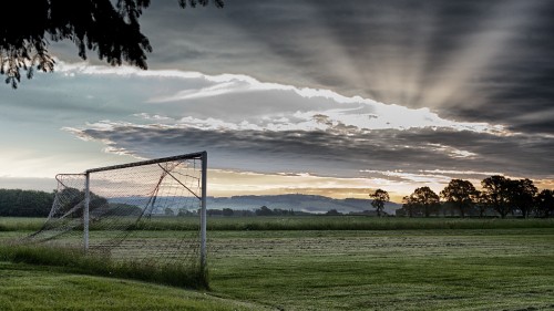 Image green grass field with brown wooden fence under white clouds during daytime