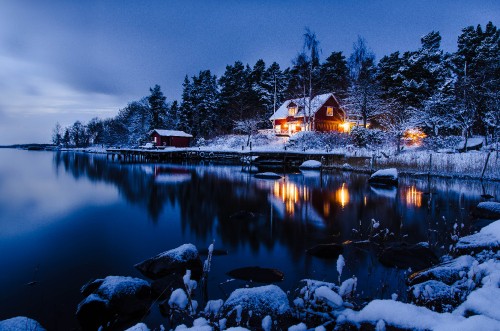 Image brown and white house near body of water during night time