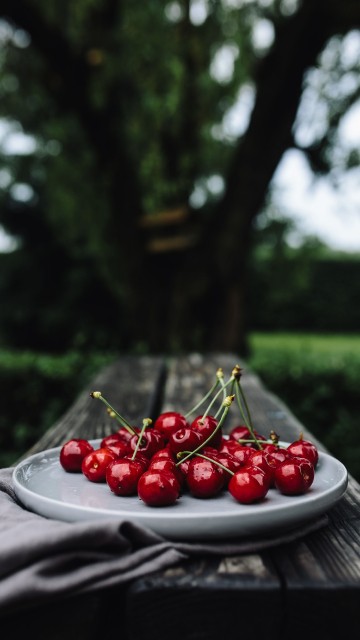 Image red cherries on white ceramic plate