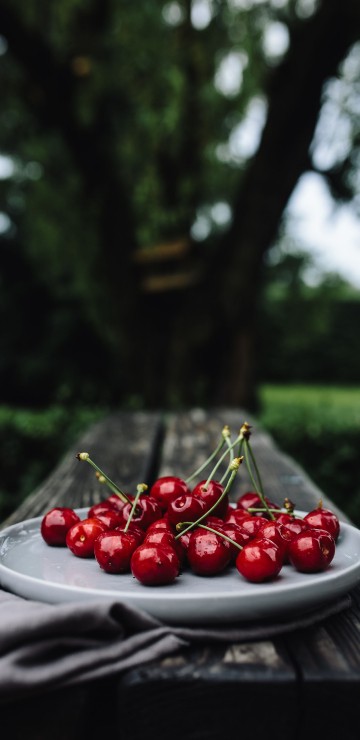 Image red cherries on white ceramic plate