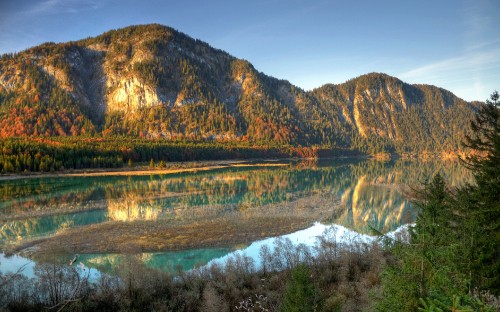 Image brown mountain beside body of water during daytime