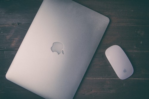 Image silver macbook on brown wooden table