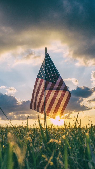 Image us a flag on green grass field under cloudy sky during daytime