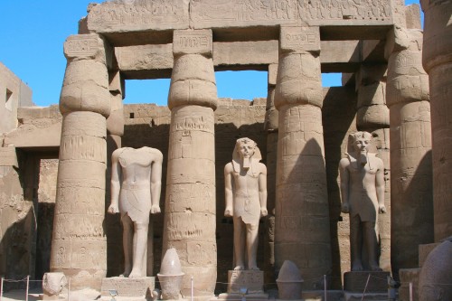 Image people standing near concrete statues during daytime