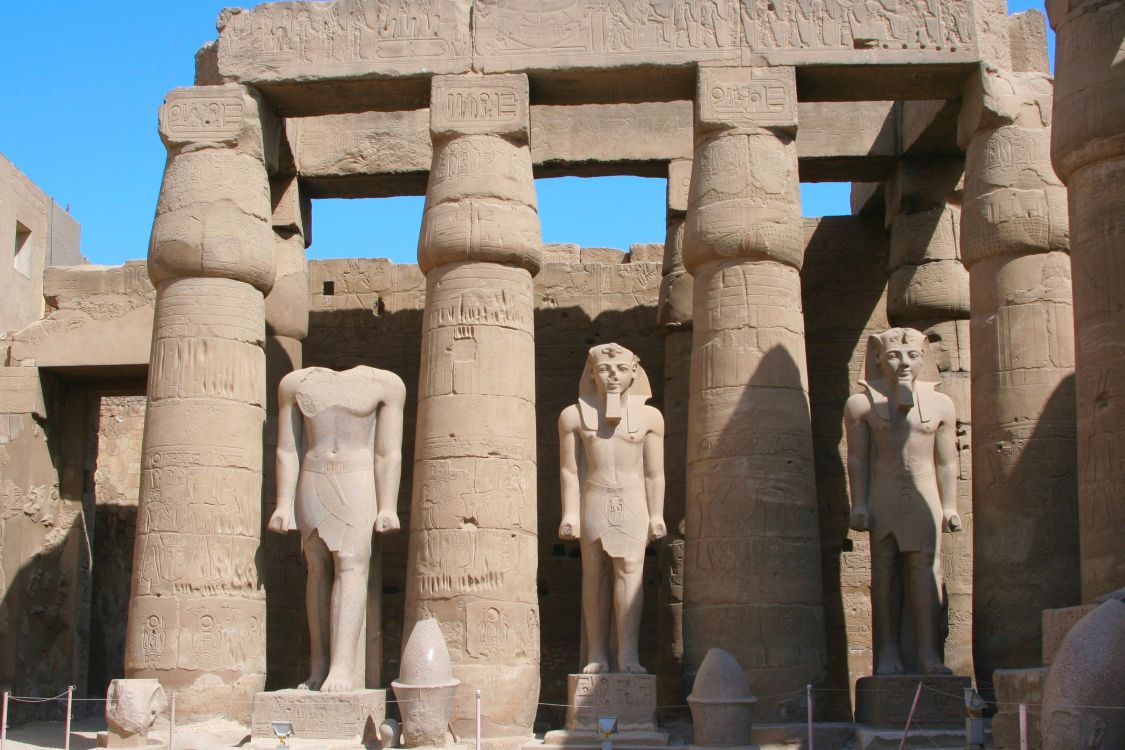 people standing near concrete statues during daytime