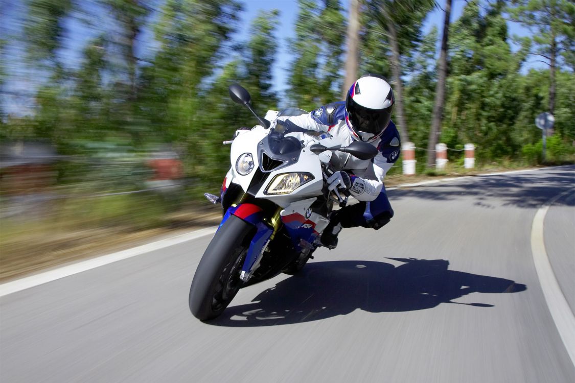 man in black helmet riding motorcycle on road during daytime