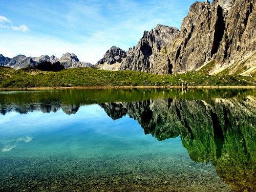 Image lake near mountain under blue sky during daytime