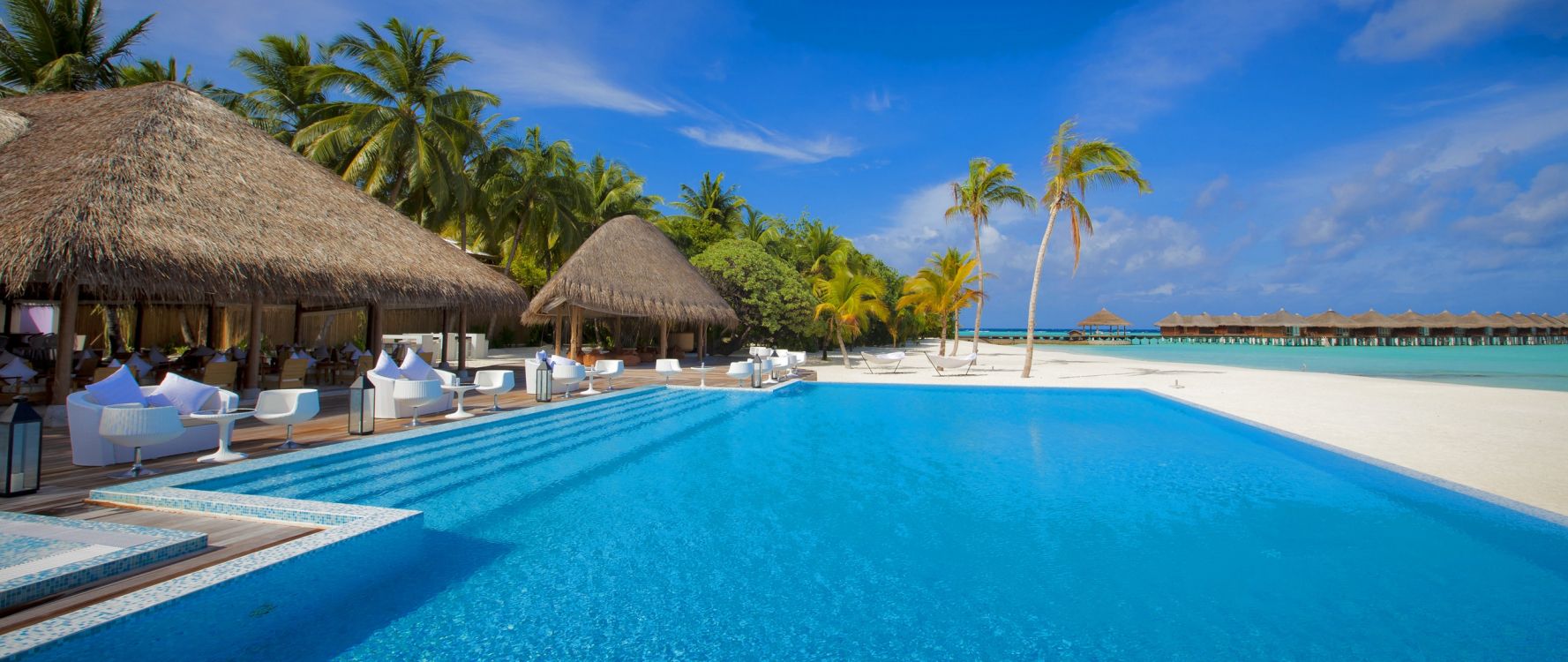 brown wooden beach house near swimming pool during daytime