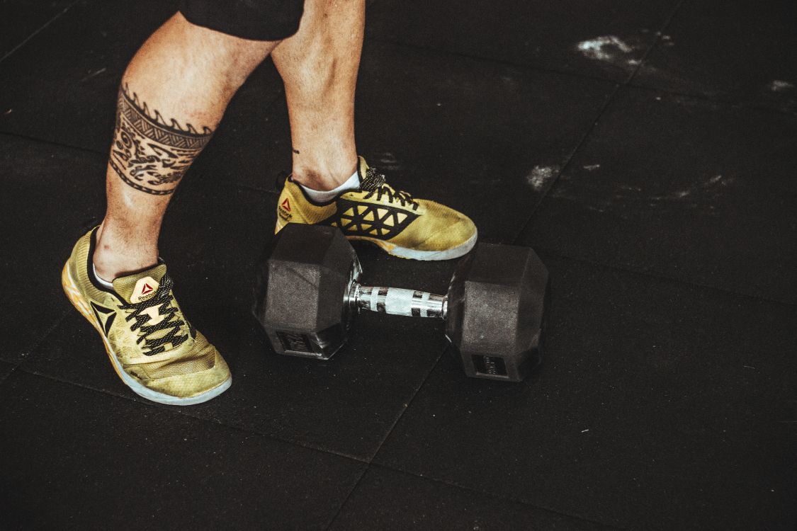 person wearing yellow and black nike athletic shoes