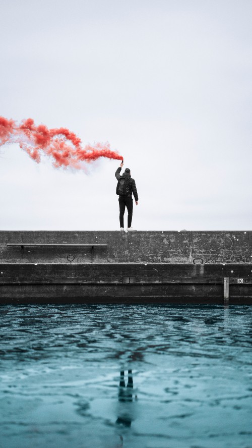 Image man in black jacket standing on concrete dock during daytime