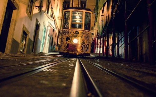 Image yellow and black tram on road during daytime