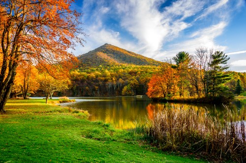 Image green and brown mountain near body of water under blue and white cloudy sky during daytime