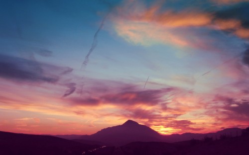 Image silhouette of mountains under cloudy sky during sunset