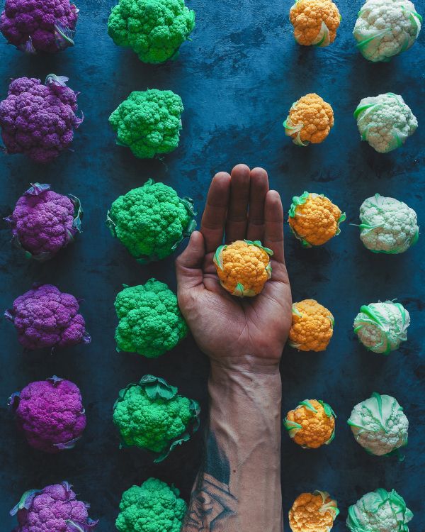 Persona Sosteniendo Flores Verdes y Moradas. Wallpaper in 1653x2066 Resolution