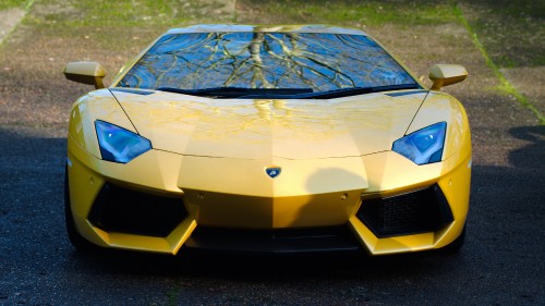 Image yellow lamborghini aventador on gray asphalt road during daytime