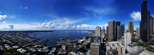 Image city skyline near sea under blue sky and white clouds during daytime