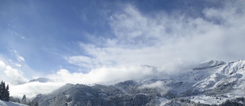 Image snow covered mountains under cloudy sky during daytime