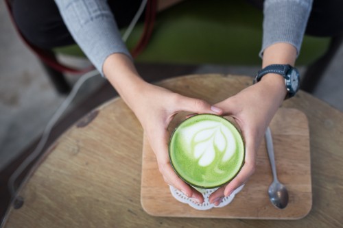 Image person holding green and white plastic cup