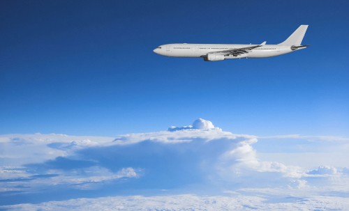 Image white airplane flying under blue sky during daytime