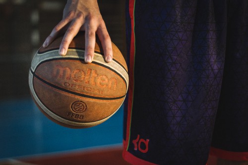 Image person holding red and black basketball