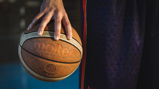 Image person holding red and black basketball