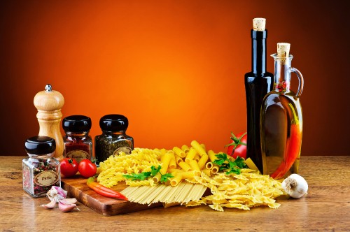 Image fries on brown wooden chopping board beside condiment shakers