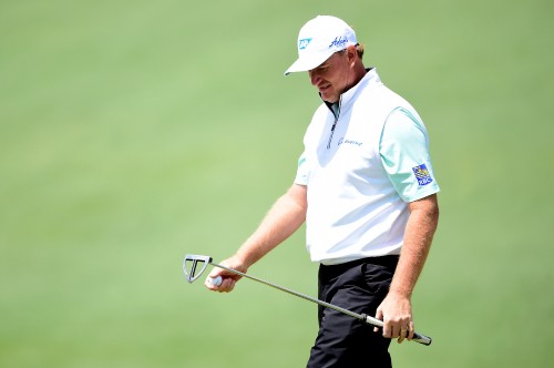 Image man in white and black polo shirt and white cap holding golf club during daytime