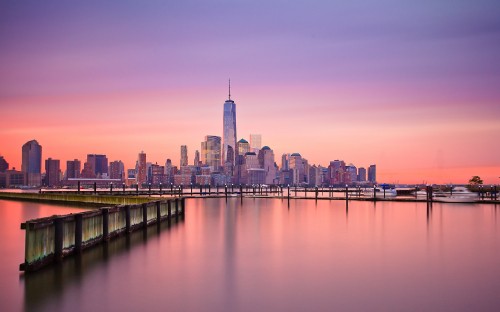 Image city skyline across body of water during daytime