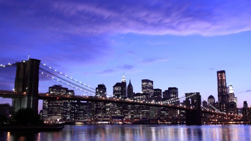 Image city skyline across body of water during night time