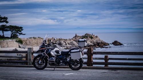 Image black and silver motorcycle parked on brown wooden dock during daytime